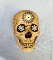 Human skull decorated with jewels and an eye. image 2
